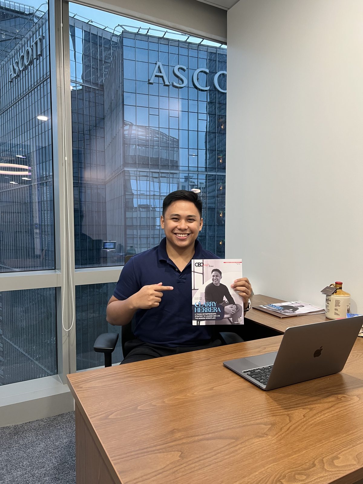 Clarry Herrera at his desk with the CEO Insights Asia issue